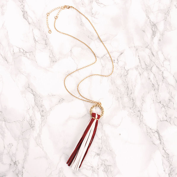 circle tassel necklace on marble counter