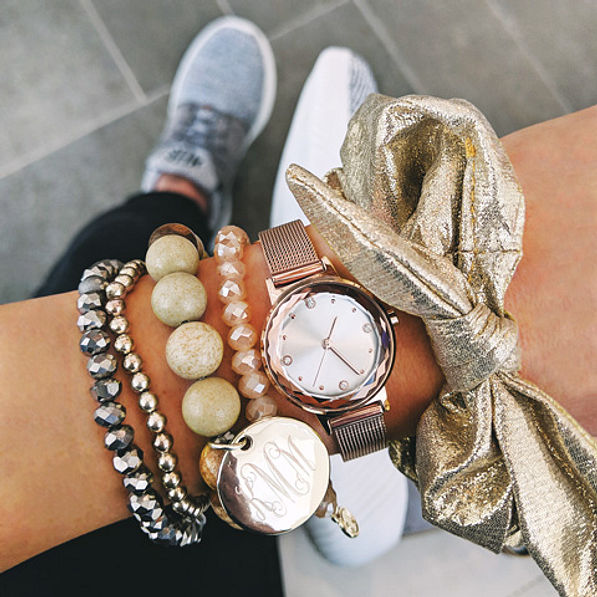 gold metallic scrunchie on wrist with watch and monogrammed bracelet