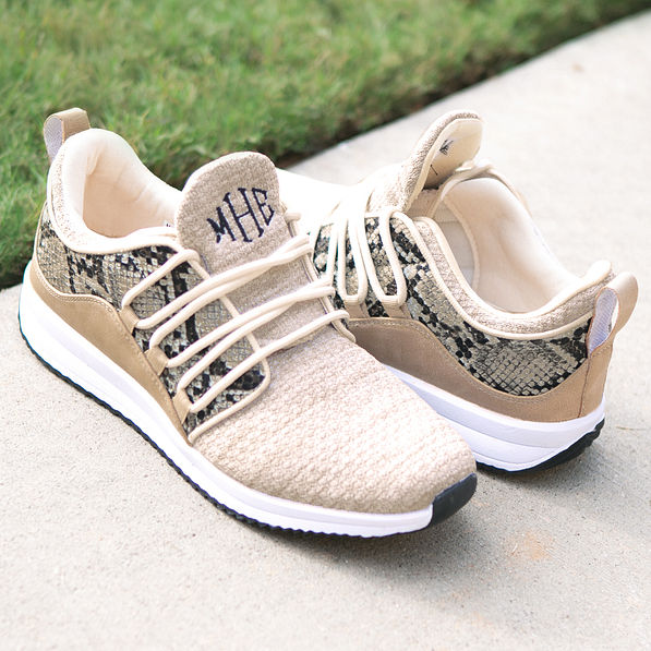 monogrammed snakeskin sneakers on pavement