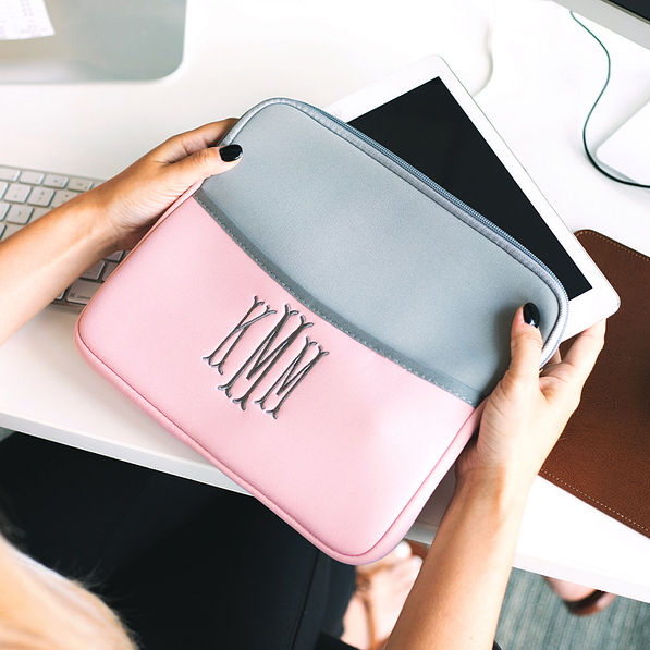blush and gray monogrammed tablet sleeve in hands at desk