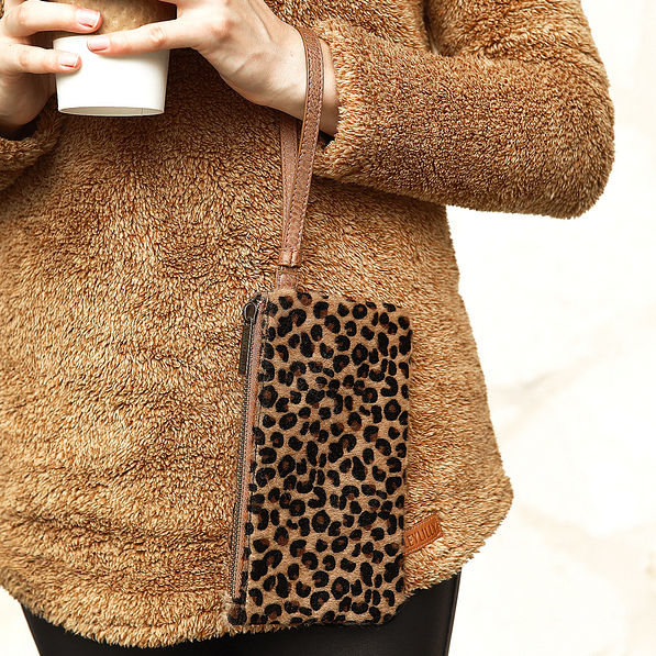 girl holding leopard clutch on wrist