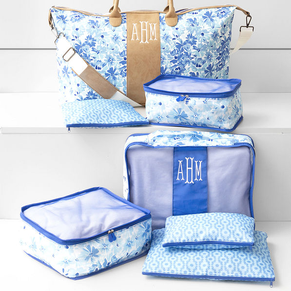blue botanical packing bag set and Charleston weekender on white bench