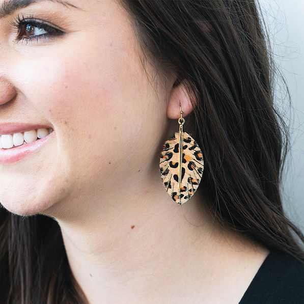leopard feather earrings in ear