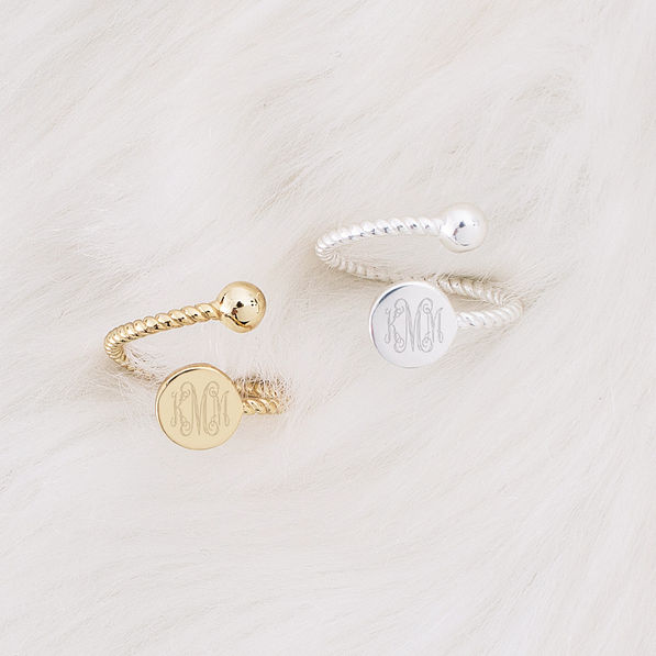 gold and silver monogrammed adjustable rings on faux fur rug