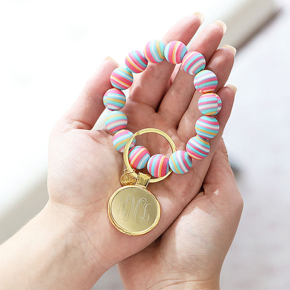 girl holding rainbow stripe key ring