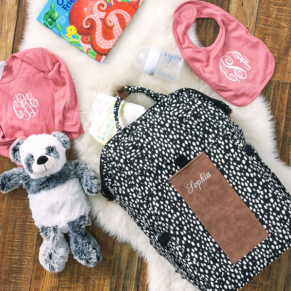 name on black dot diaper bag with baby items