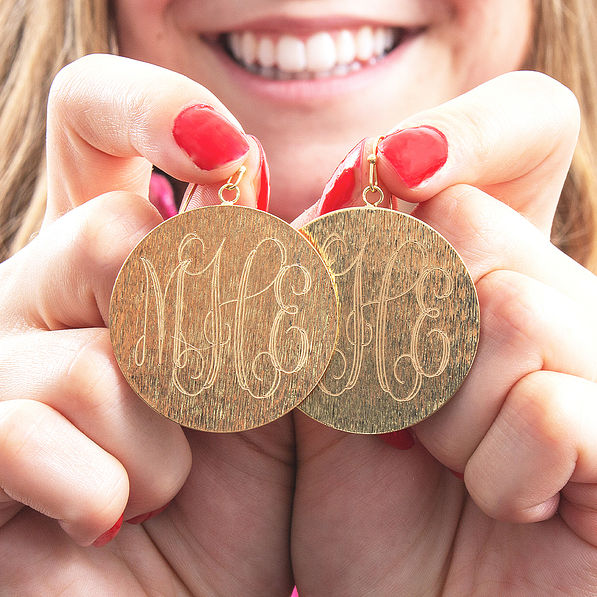 girl holding monogrammed gold brushed drop earrings