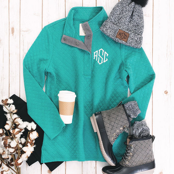 teal monogrammed quilted pullover with black duck boots and beanie