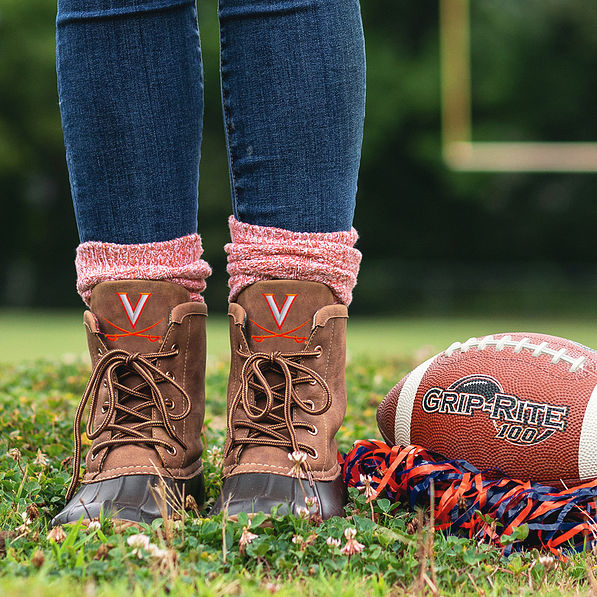 uva duck boots on football field with pom pom and football