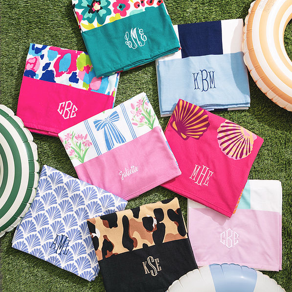 multiple monogrammed beach towels on turf