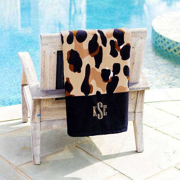 classic cheetah beach towel draped over deck chair