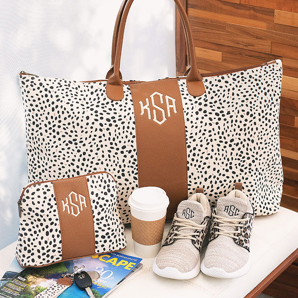 monogrammed spotted weekender and cosmetic bag on bench
