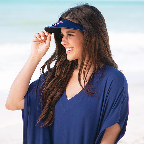 girl wearing sun visor and coverup at beach