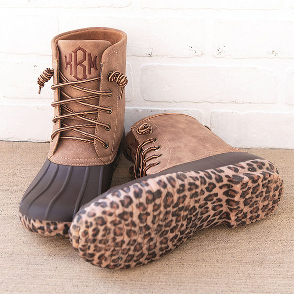 leopard bottom duck boots by white brick wall