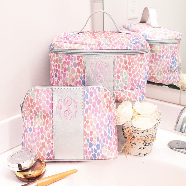 monogrammed watercolor cosmetic and train cases on bathroom counter