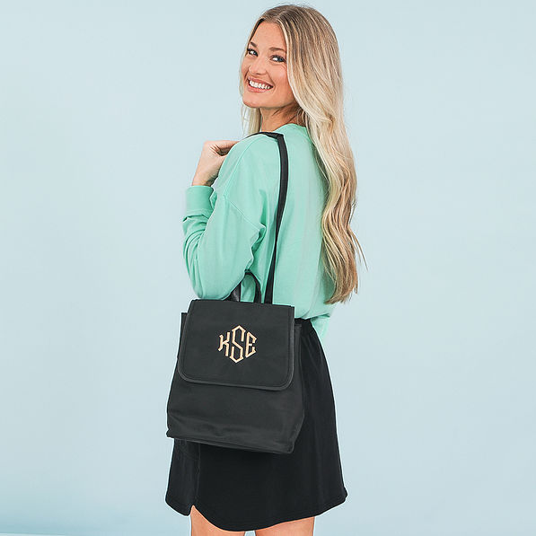 girl with black monogrammed backpack purse over shoulder