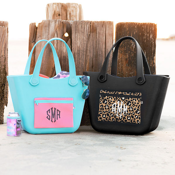 Blue waterproof tote and cheetah tote by the beach