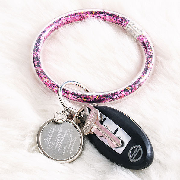 pink monogrammed confetti key ring on fuzzy rug
