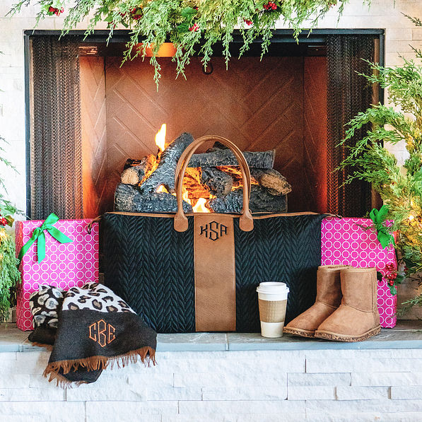monogrammed black and brown quilted travel bag on fireplace
