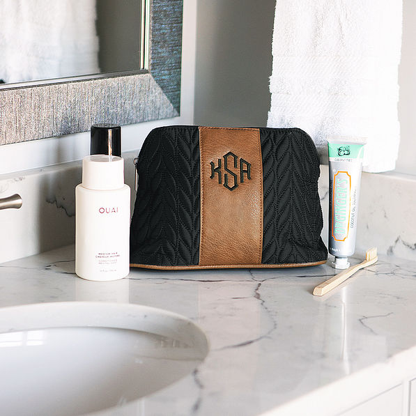 black and brown quilted travel makeup bag on  countertop