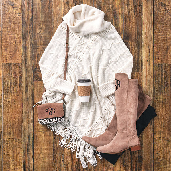 cable knit poncho sweater with riding boots and crossbody