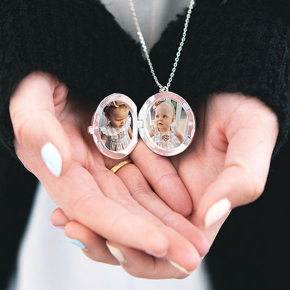 silver monogrammed locket with photos of little girls