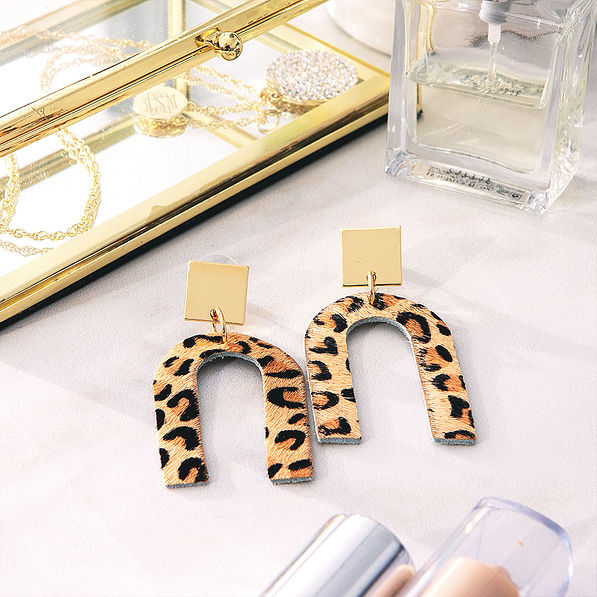 leopard print horseshoe earrings beside jewelry box
