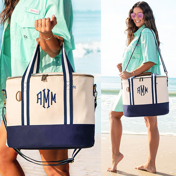 monogrammed canvas cooler in navy blue at beach on shoulder and wrist