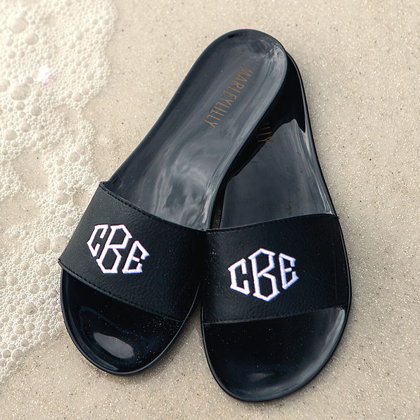 black monogrammed jelly slides on the shoreline