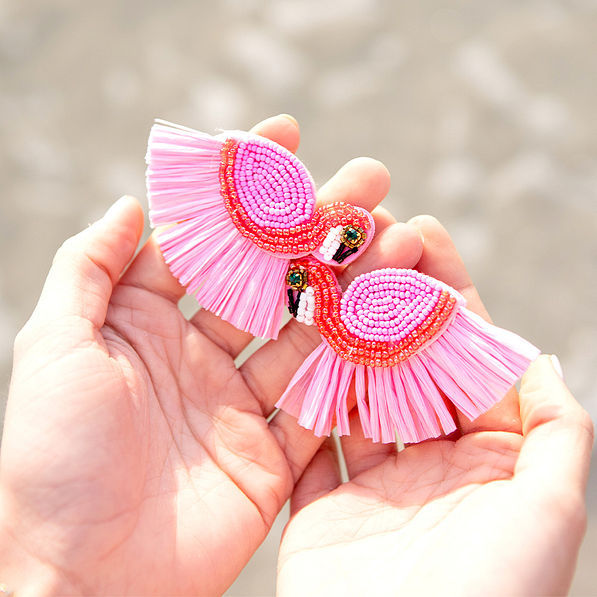 earrings in hands on beach