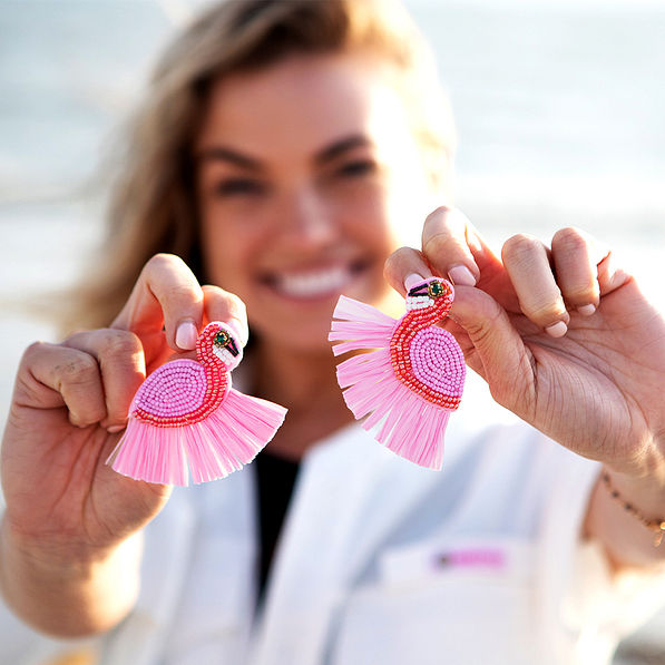 girl on beach holding earrings