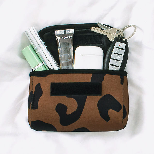 neoprene travel pouch with cosmetics and airpods in hickory leopard