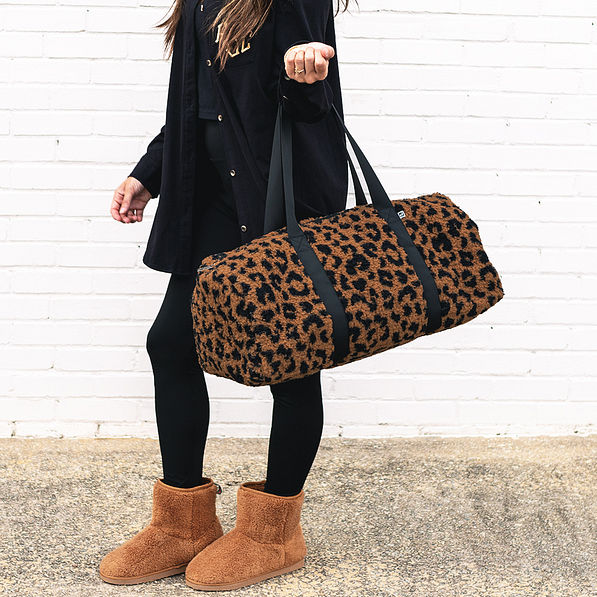 sherpa fuzzy duffel bag in hickory leopard on wrist