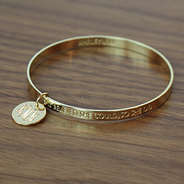 Gold Inspirational Bracelet on Wood Table