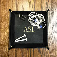 mens black valet tray holding cuff links and headphones