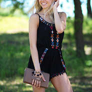 monogrammed clutch in brown paired with a black romper