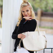 Model wearing gold personalized purse on shoulder