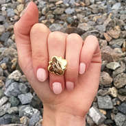girls hand wearing gold quatrefoil ring