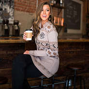 model drinking coffee in embroidered tan antlers pullover