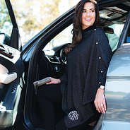 girl getting our of a car wearing the Monogrammed Luxe Poncho in black shimmer