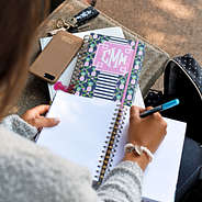 girl writing in monogrammed pineapple notebook