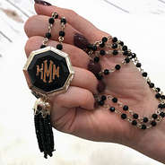 Model holding Tassel Pendant Necklace with Rosary Beads