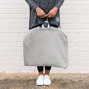 girl holding monogrammed quilted garment bag