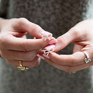 bow earrings in hands