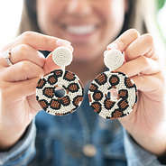 girl holding leopard earrings