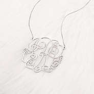 close up of silver monogrammed lacey necklace