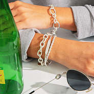 personalized bracelet in silver styled with silver bracelets on cafe table