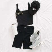 crossover bike shorts styled with sneakers, baseball hat, sunglasses, and tumbler