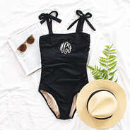 black one piece bathing suit flatlay