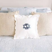 monogrammed white scalloped pillow sham on bed